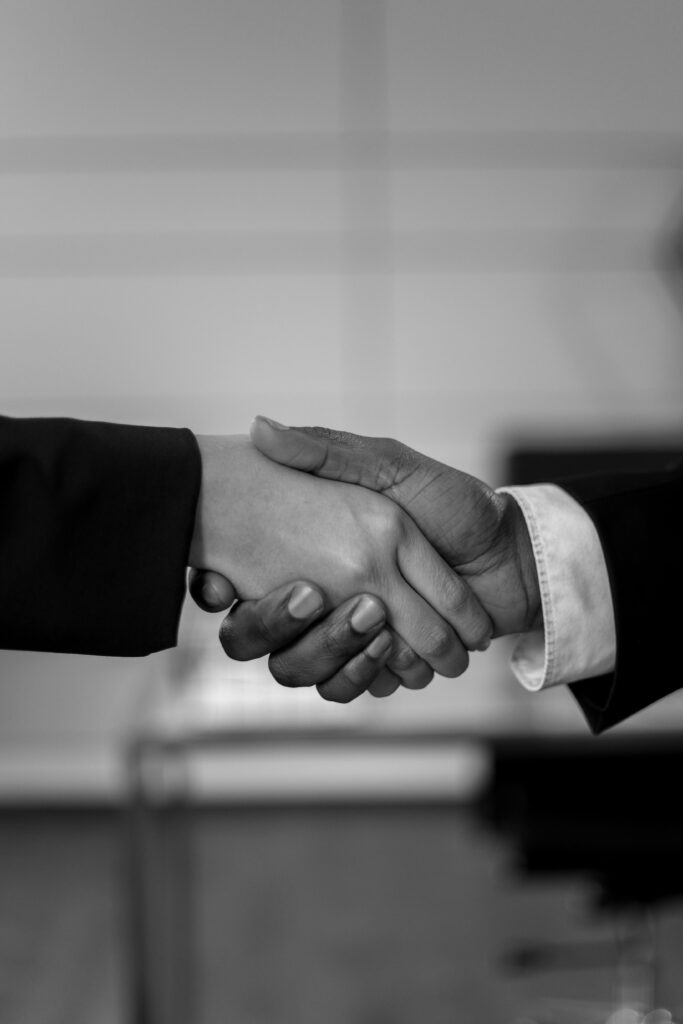 pexels-photo-6077647-6077647 Close-up of a professional handshake in black and white, symbolizing agreement and partnership.